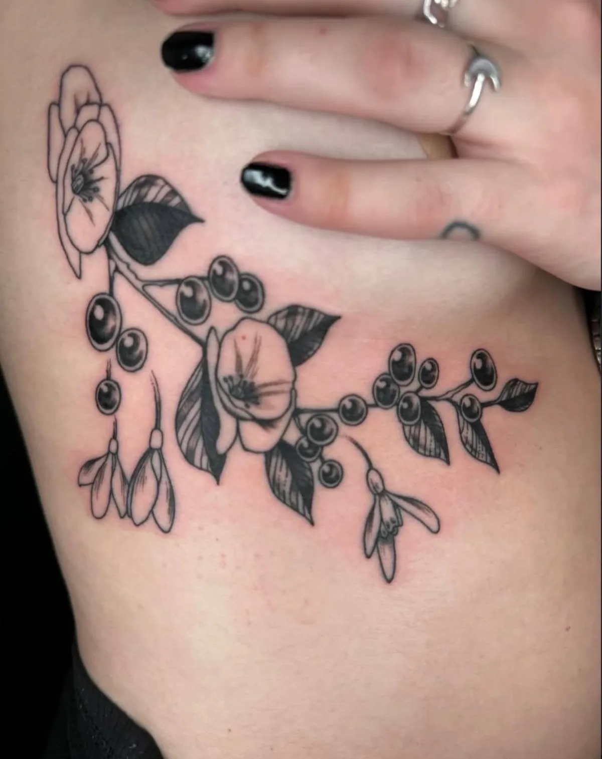 Blackwork floral and berry tattoo by Corvus Caine